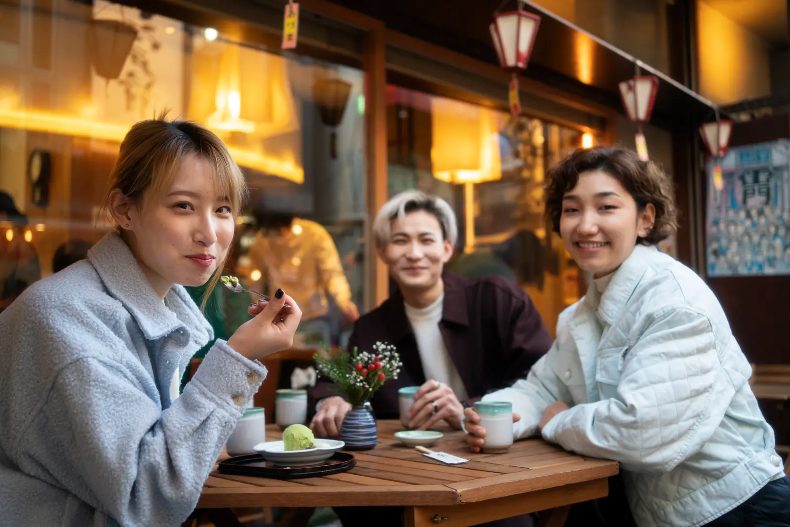 Friends sharing matcha dessert outside a restaurant
